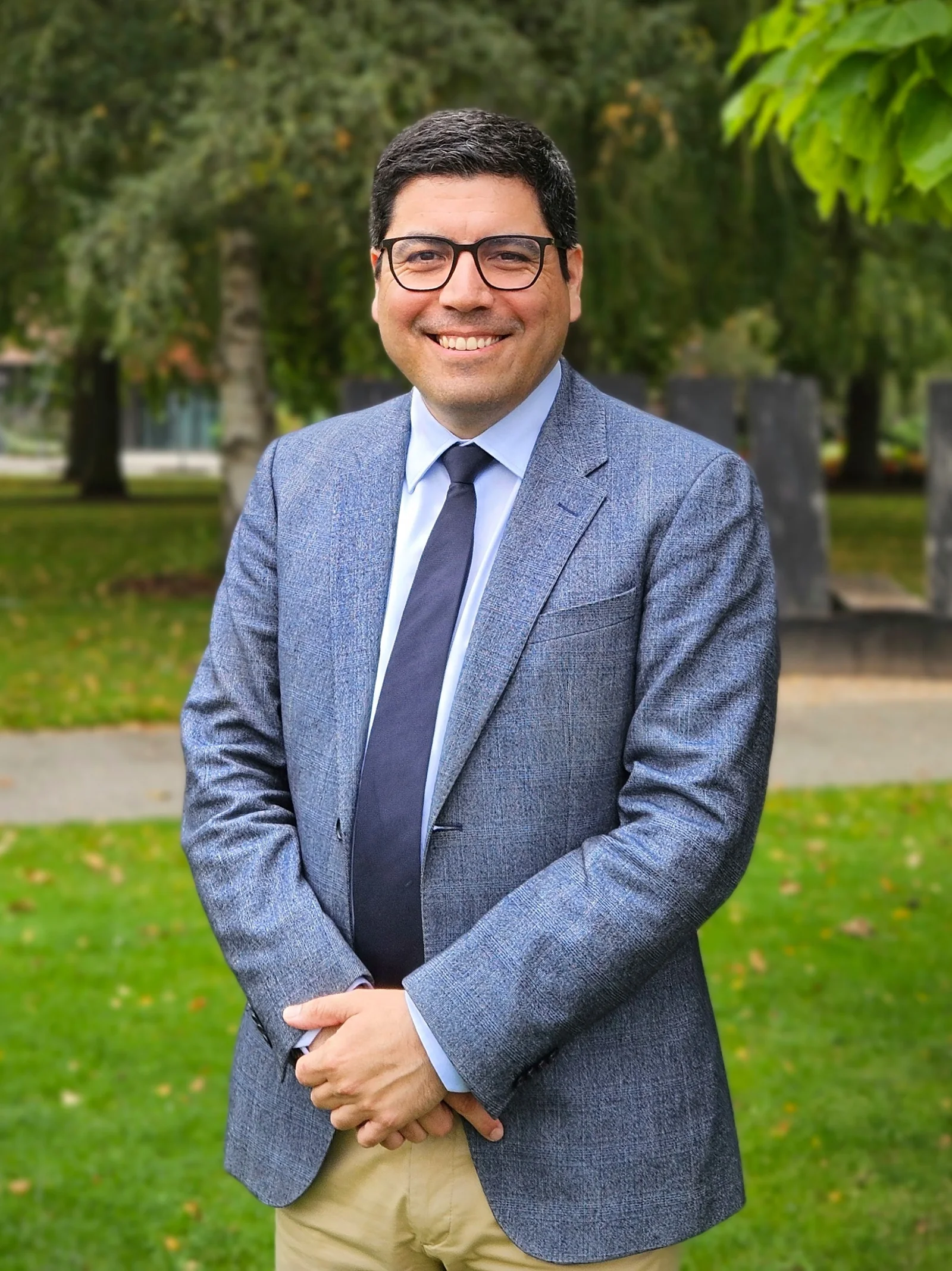 Hernán Cáceres con chaqueta y corbata, al aire libre